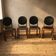 Set of four vintage wooden dining chairs with black leather upholstery