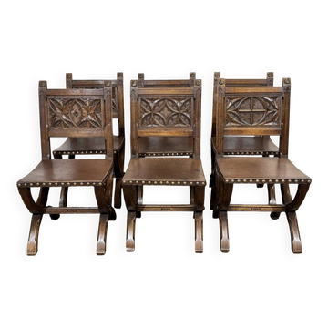 Set of 6 chairs and 2 armchairs in oak and leather with Gothic decoration.