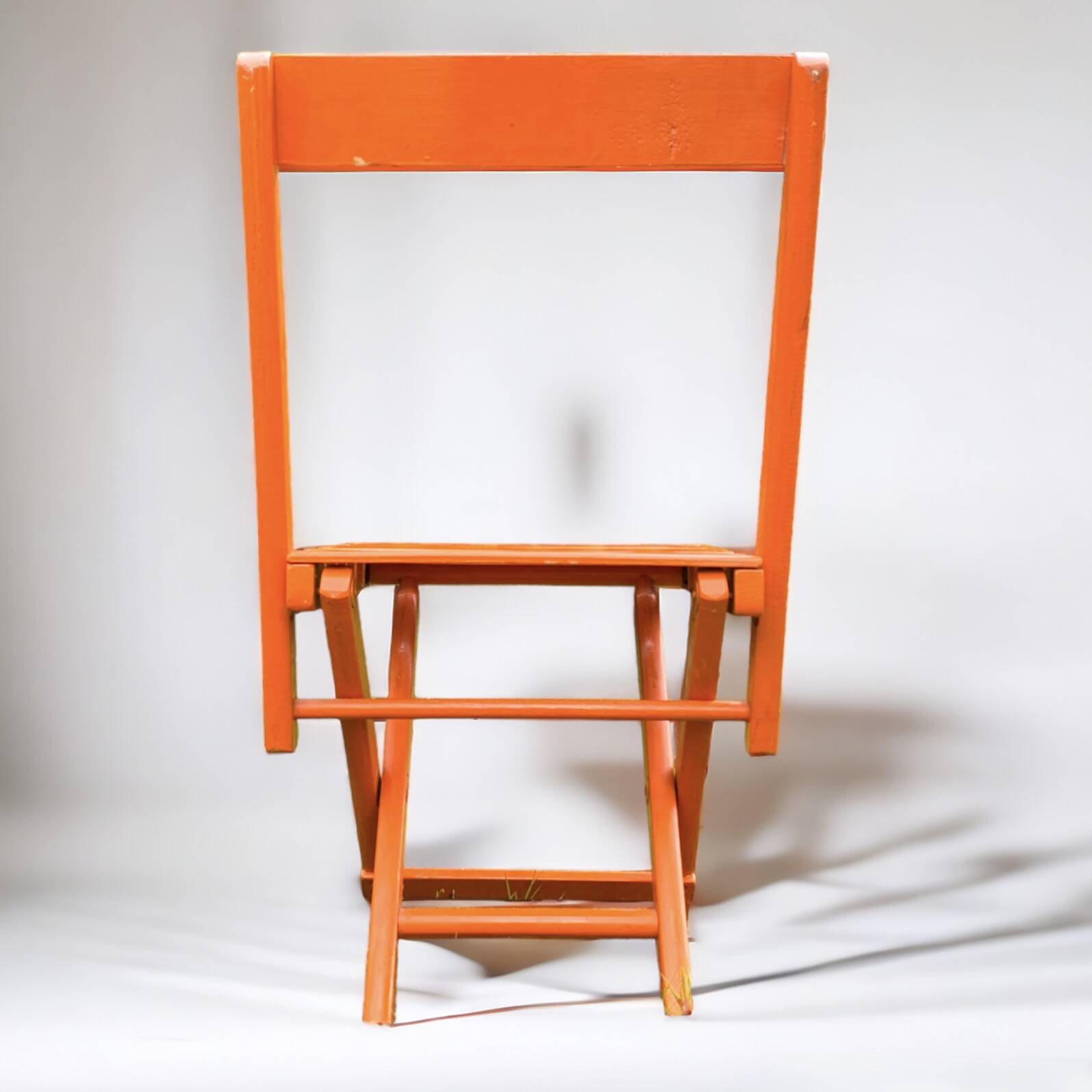 Vintage folding chair in orange painted wood