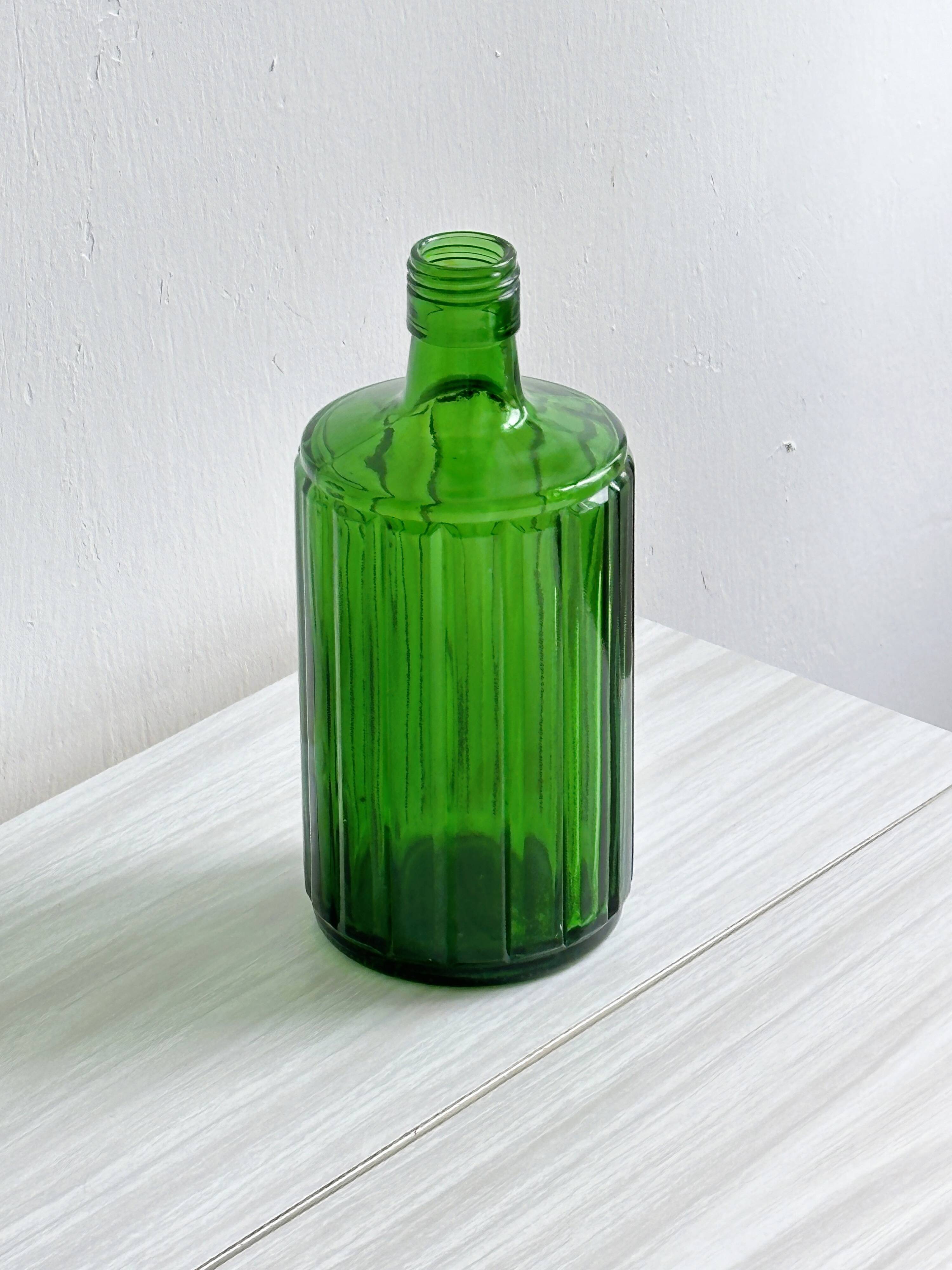 Green glass bottle, ribbed design.