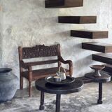 Small antique Indonesian bench in carved teak with plant and floral motifs.