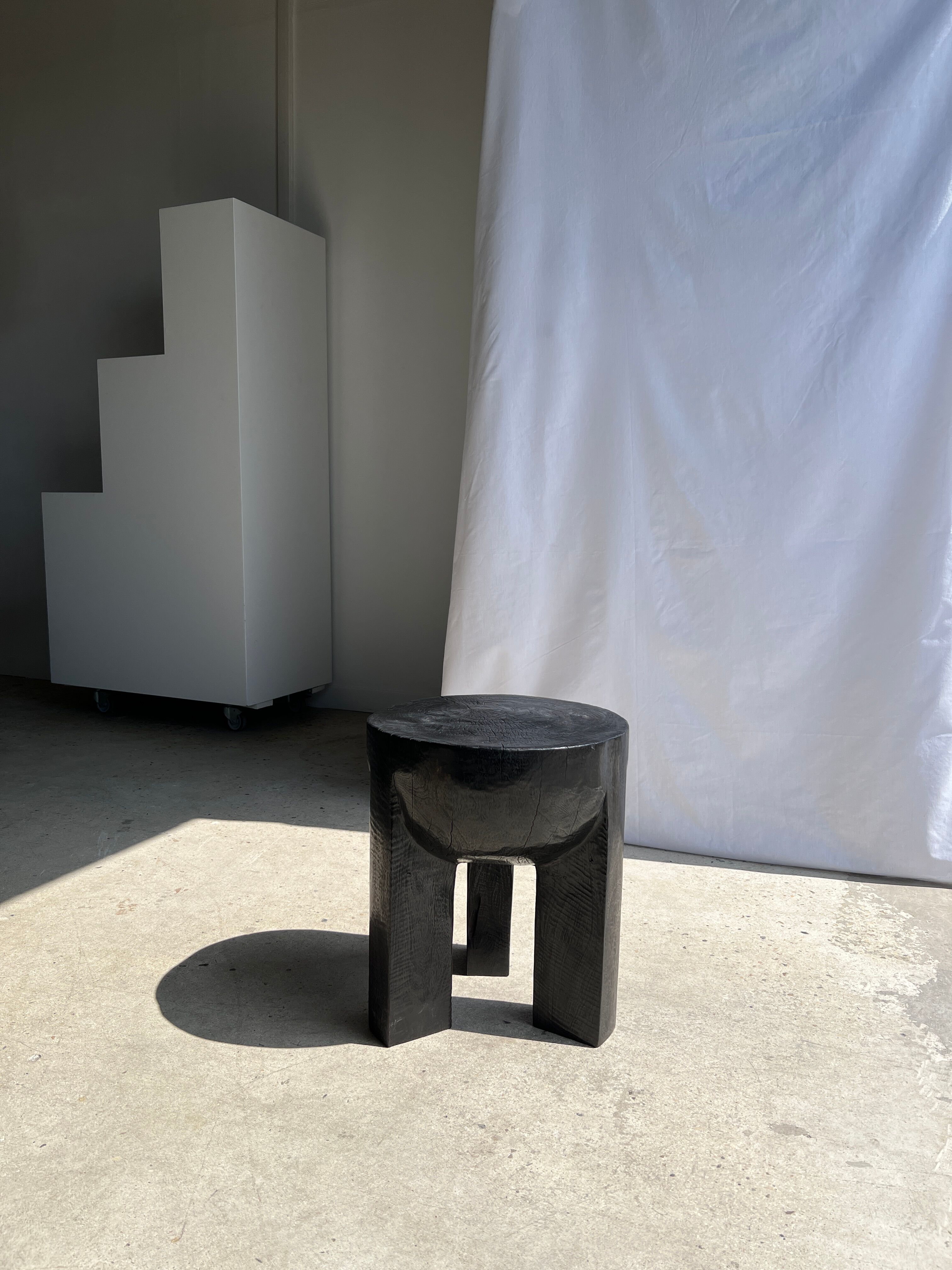 Black mango wood tripod side table with a semi-spherical top, height: 45 cm, diameter: 44 cm.