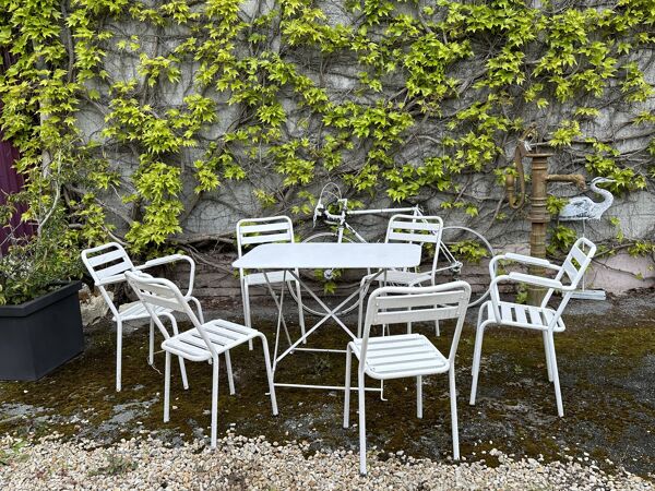 Salon de jardin en fer forgé et lattes de bois composé de deux fauteuils, 4 chaises  et d'une table.