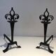 Important pair of wrought iron andirons with torch in heraldic fleur-de-lis design.