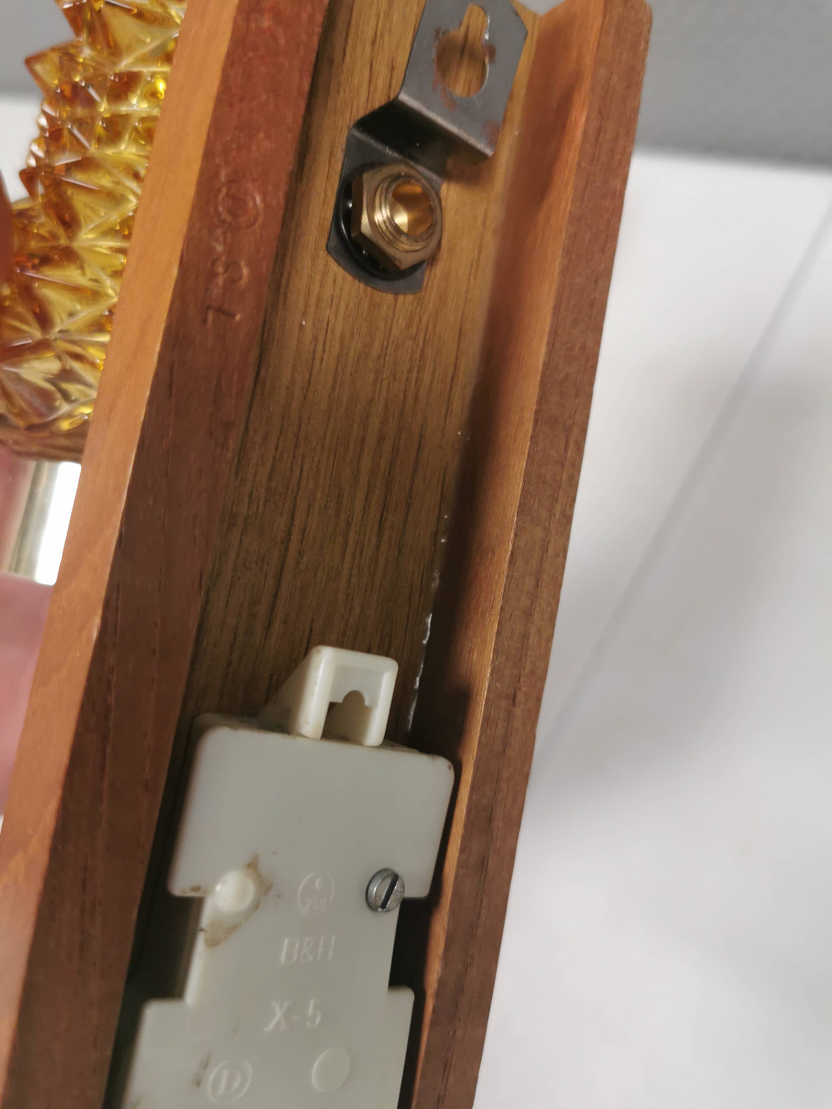 A set of wall lamps in teak wood, with amber colored glass
