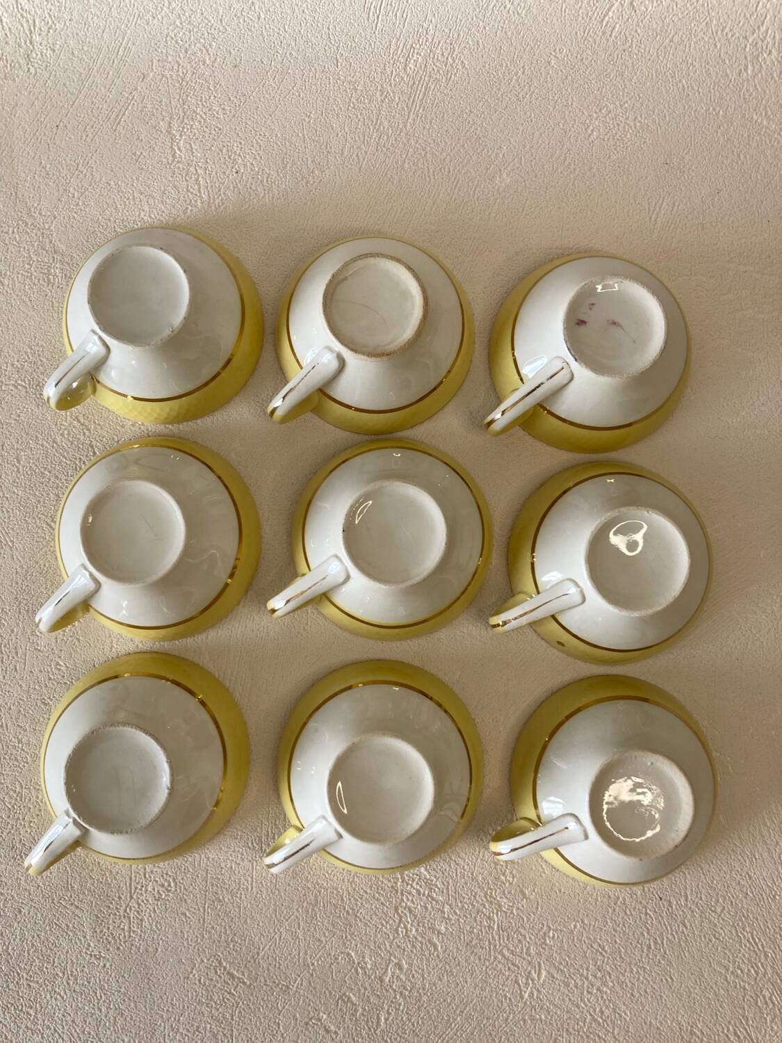 Yellow and white cups and saucers with gold trim Moulin des loups