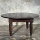Antique round coffee table in Indonesian teak with turned legs.