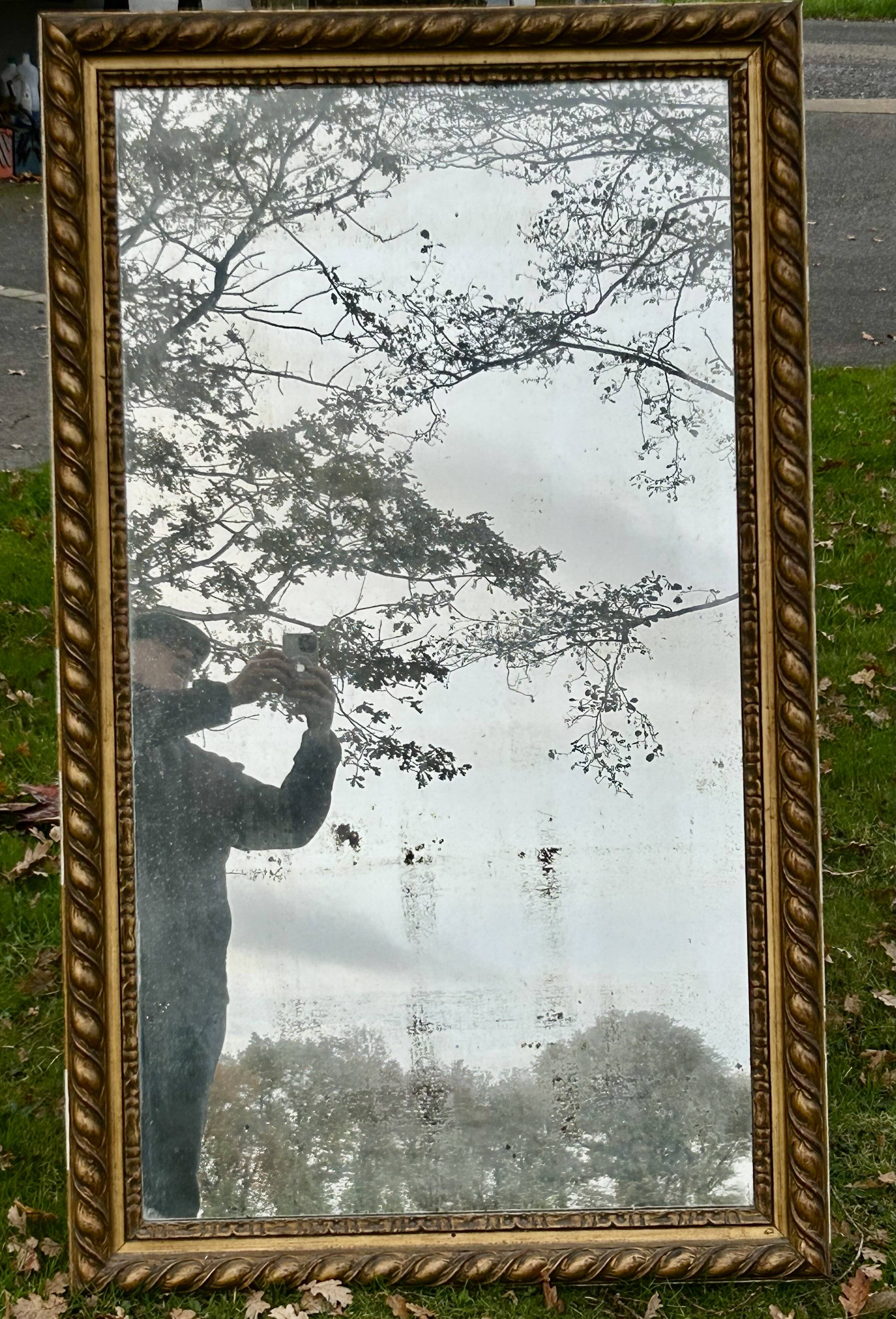 Large antique gilded mirror, wood and stucco gadroons, partially de-mercury