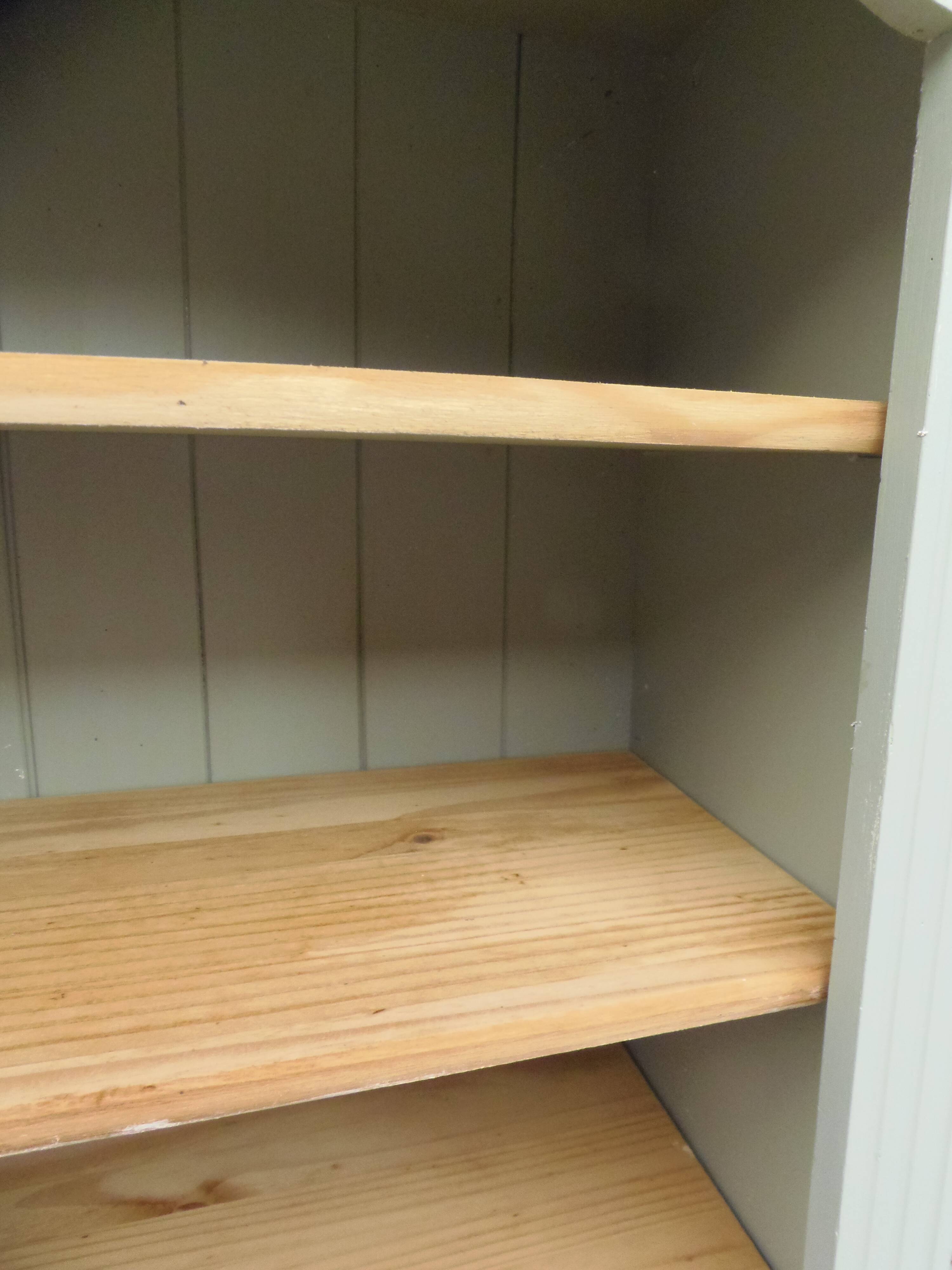 Green-grey library, wooden shelf and shelves in natural wood.