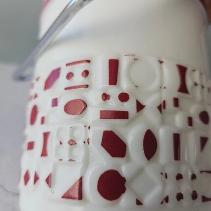 Vintage white opaline ice bucket with red patterns.