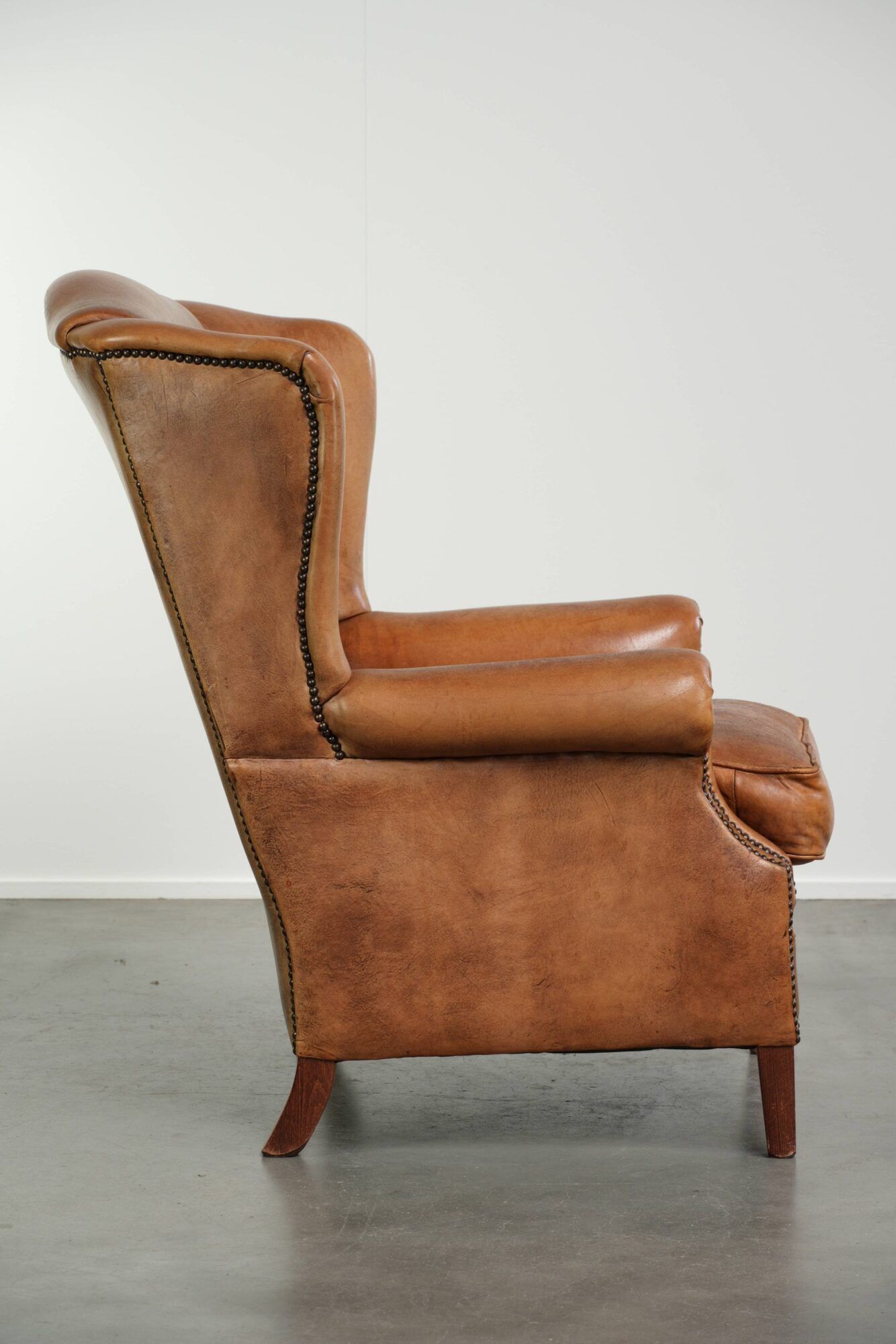 Sheepskin wingback armchair in a light cognac colour in English style