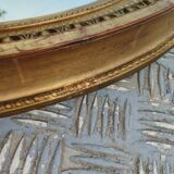 Antique oval mirror in gilded stucco with gold leaf, 19th century