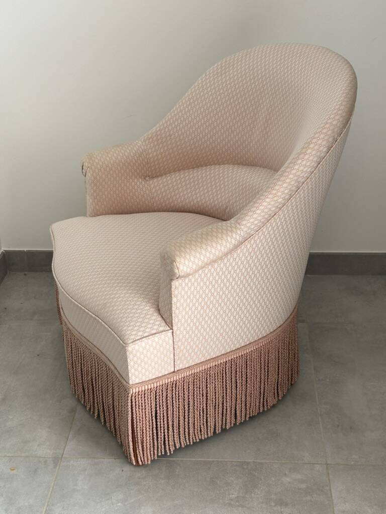 Pink armchair with patterns and fringes.