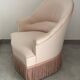 Pink armchair with patterns and fringes.