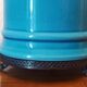 Blue ceramic lamp with claw feet and foliage lampshade.
