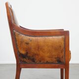 Sheepskin and wooden vintage Art Deco design armchair in a cognac color