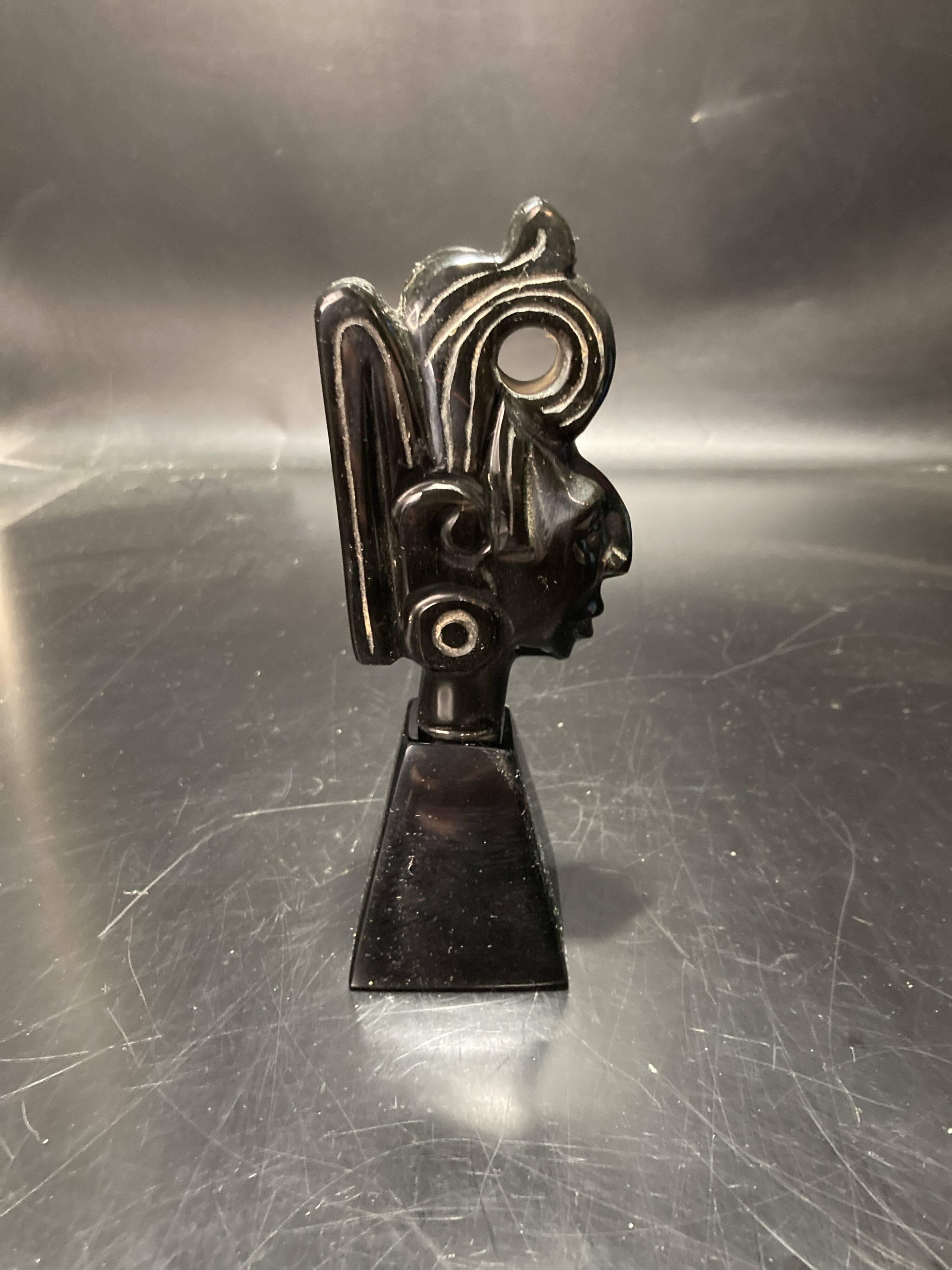 Ceramic sculpture representing a woman's face placed on a black base
