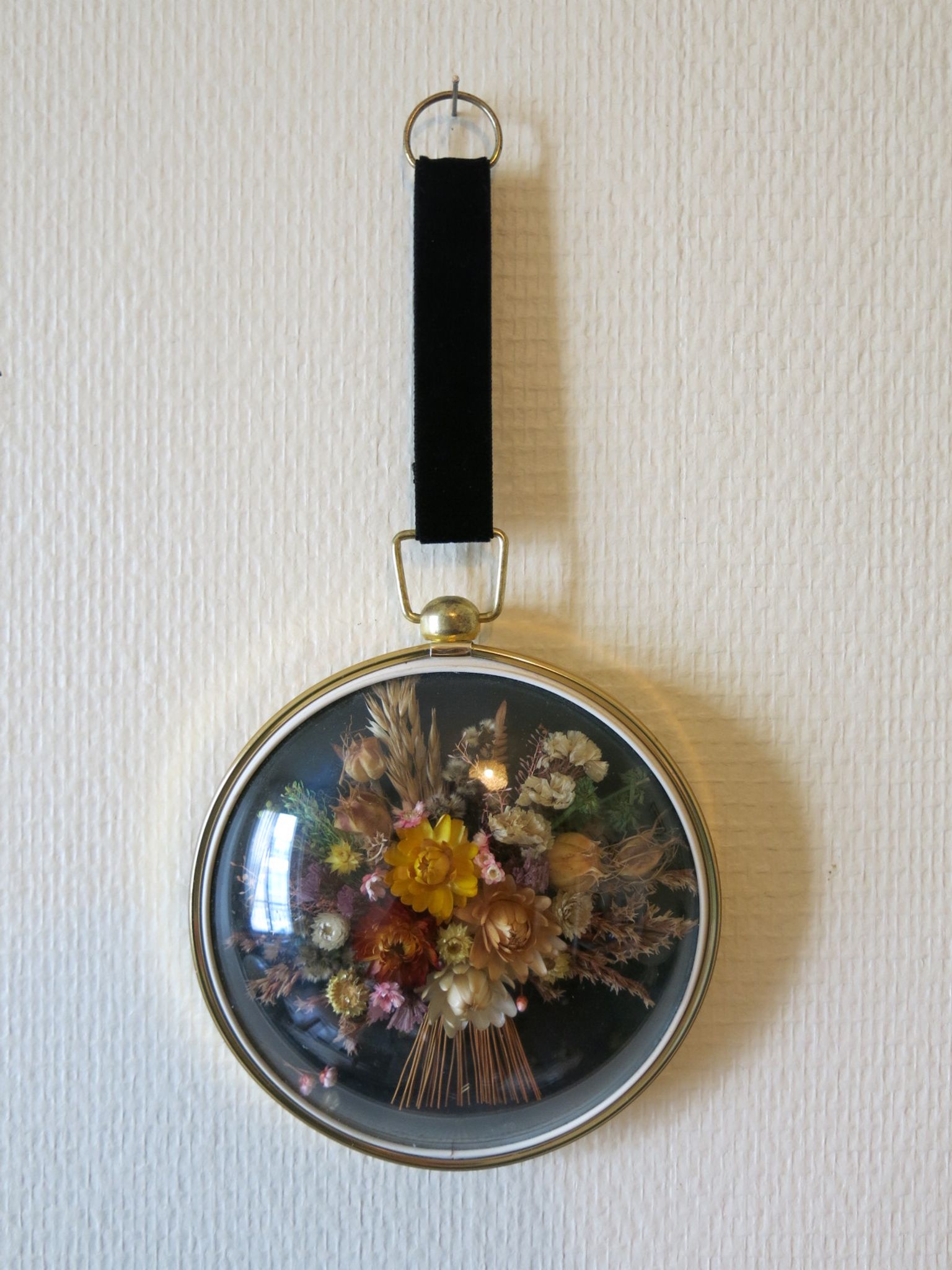 Vintage medallion of dried flowers decorative frame in domed glass and brass