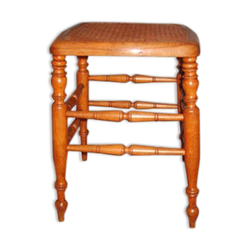 Turned wooden stool with a caned seat.