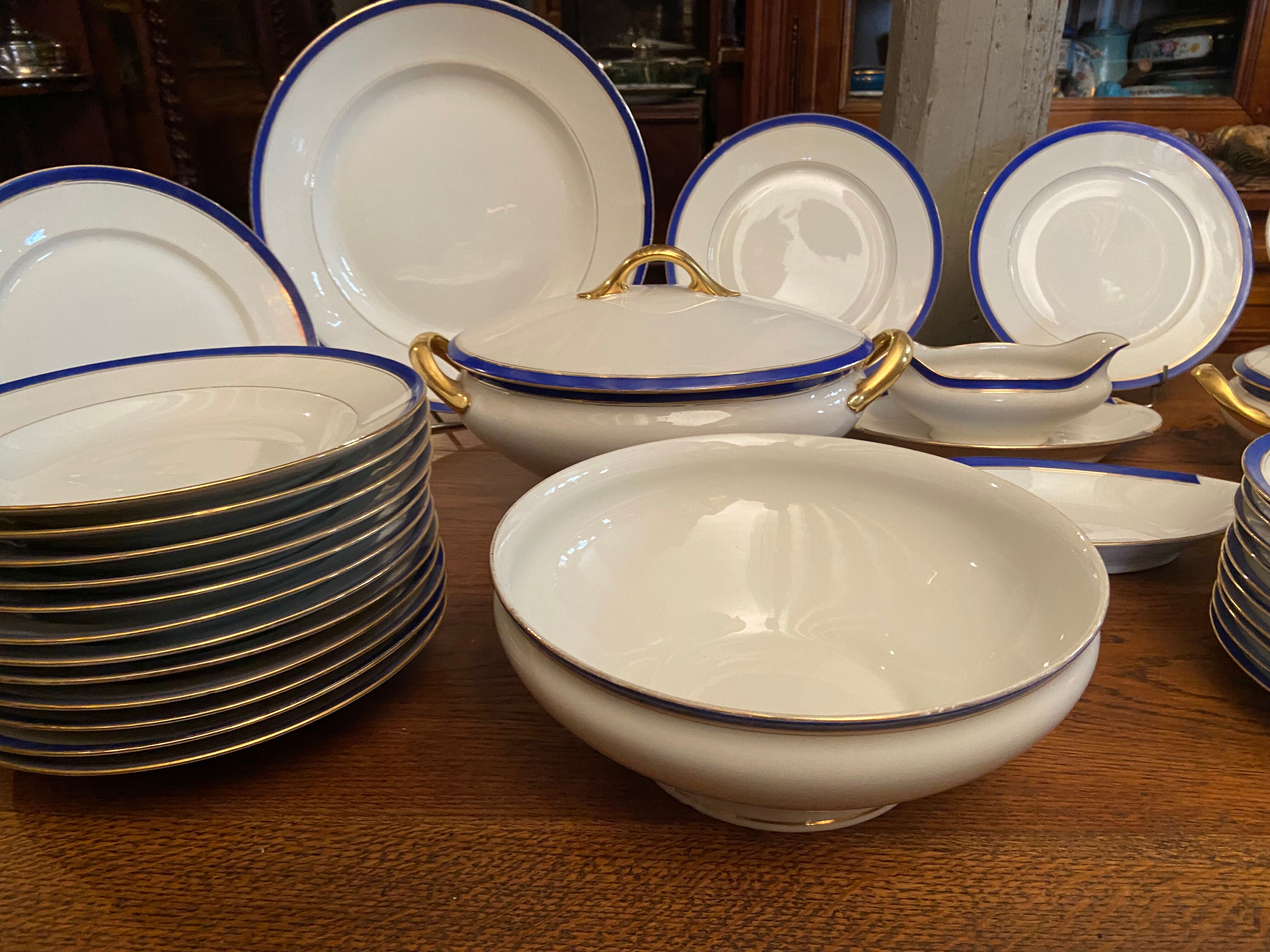 Service de table en porcelaine de Limoges à bandeau bleu sur fond blanc et or