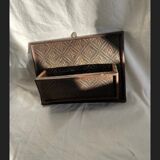 Hammered leather wall mail holder on wood.