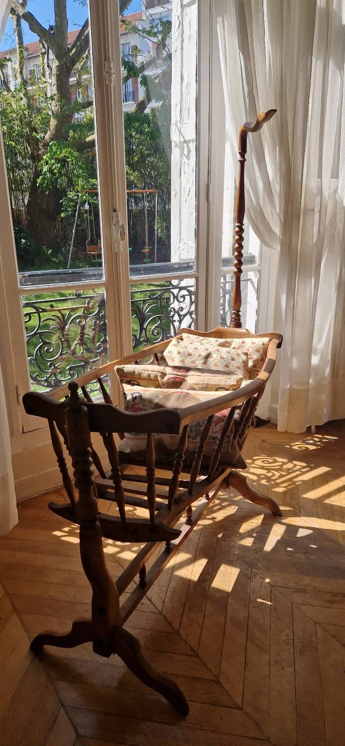 Wooden cradle in walnut with a sign collar at the top.