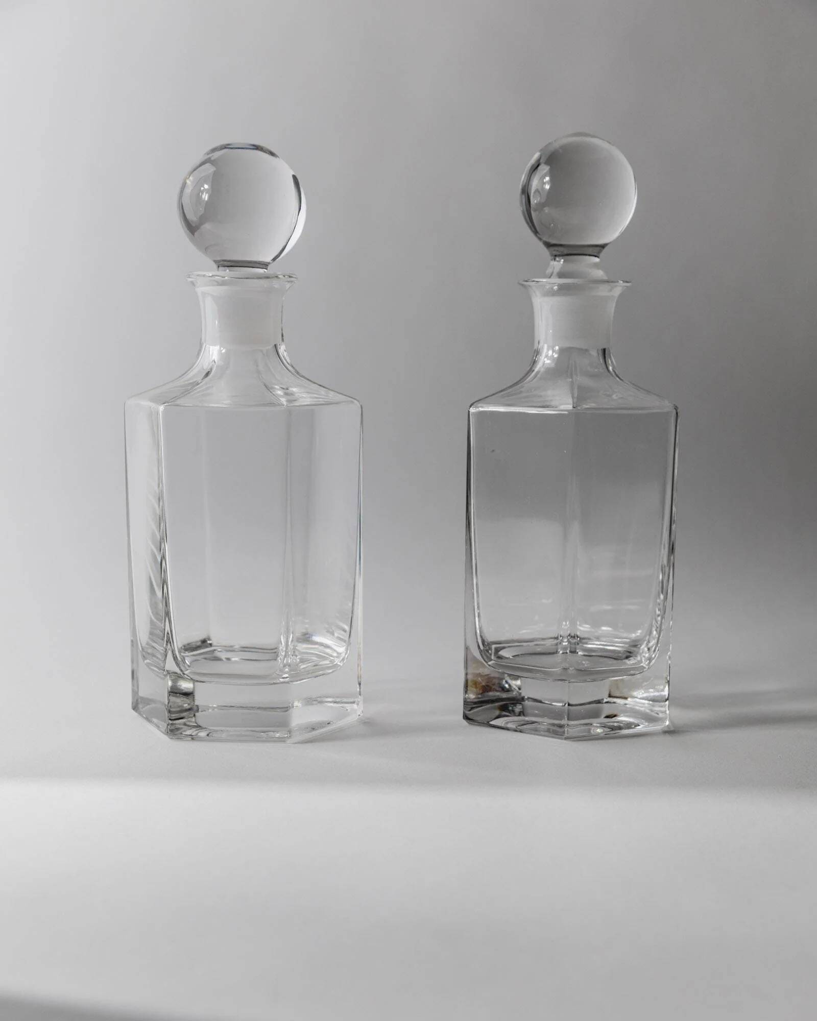 Lot of vintage 1970s consisting of 2 hexagonal glass carafes, transparent glass with spherical stoppers.