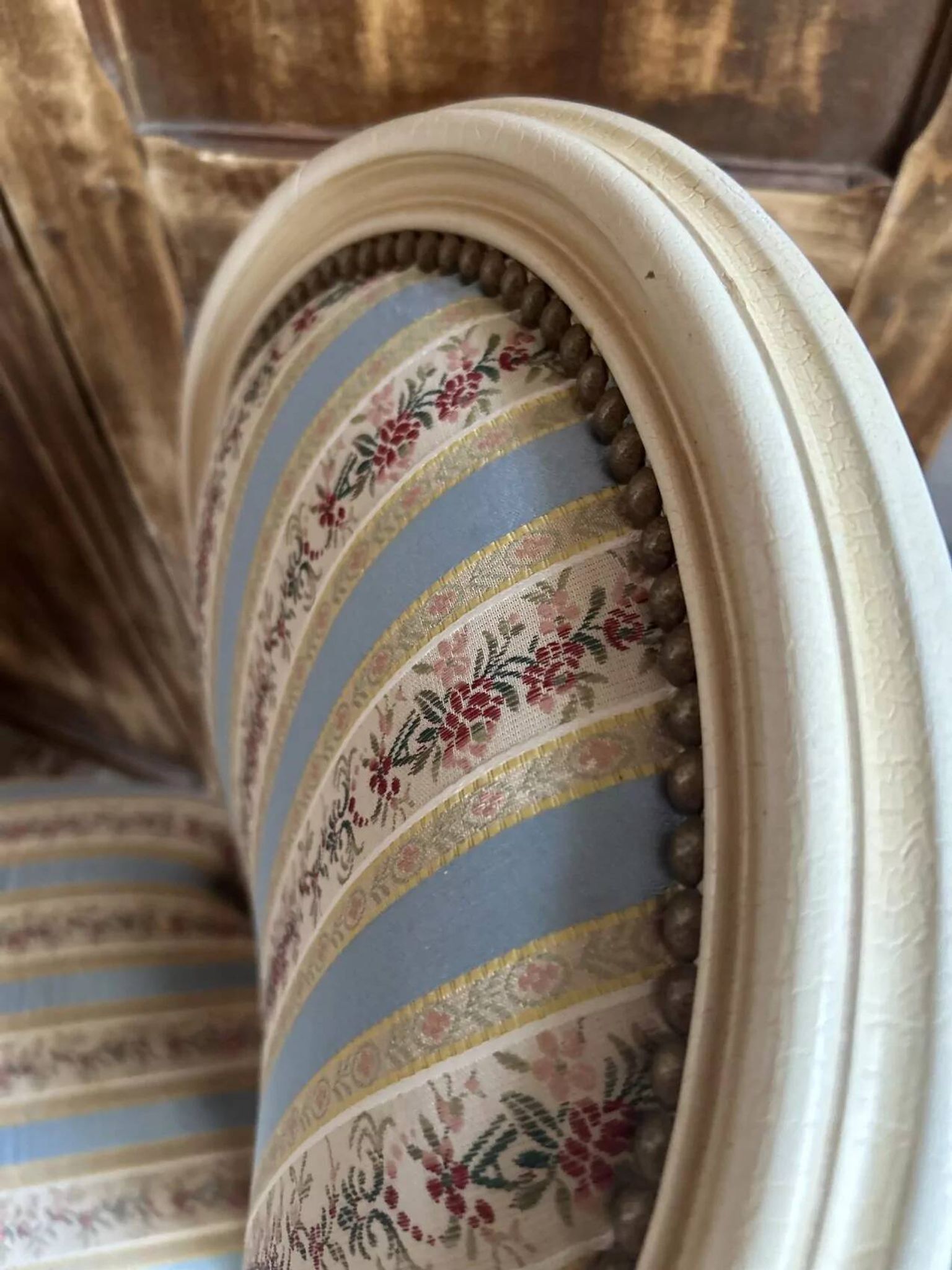 Pair of Louis XVI style chairs in painted wood and satin, classic elegance.
