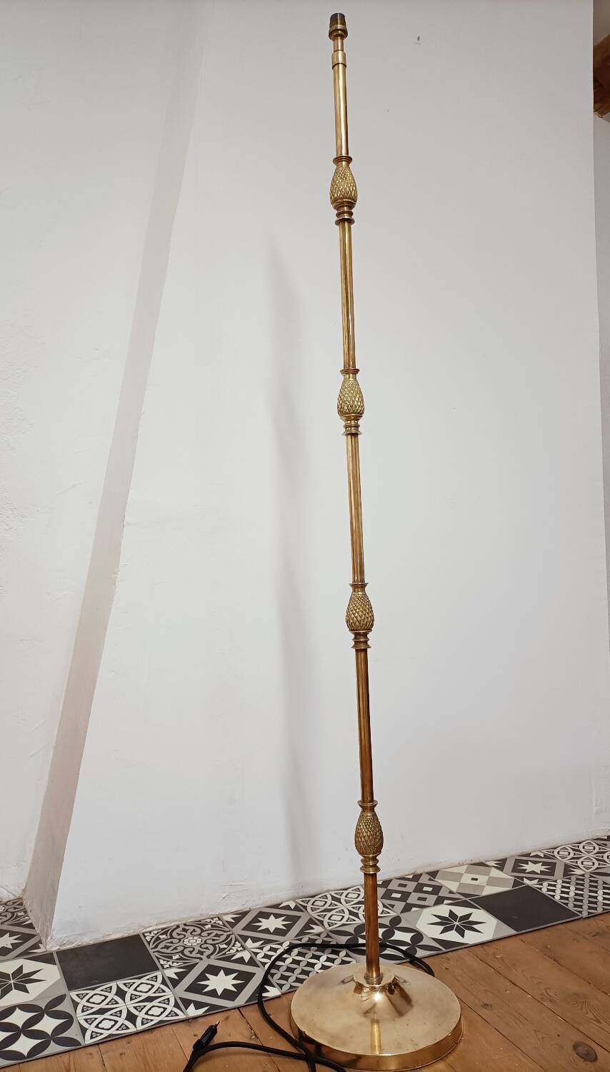 Bronze floor lamp with pine cone decoration.