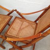 Pair of folding chairs in bamboo and caning, leather and brass
