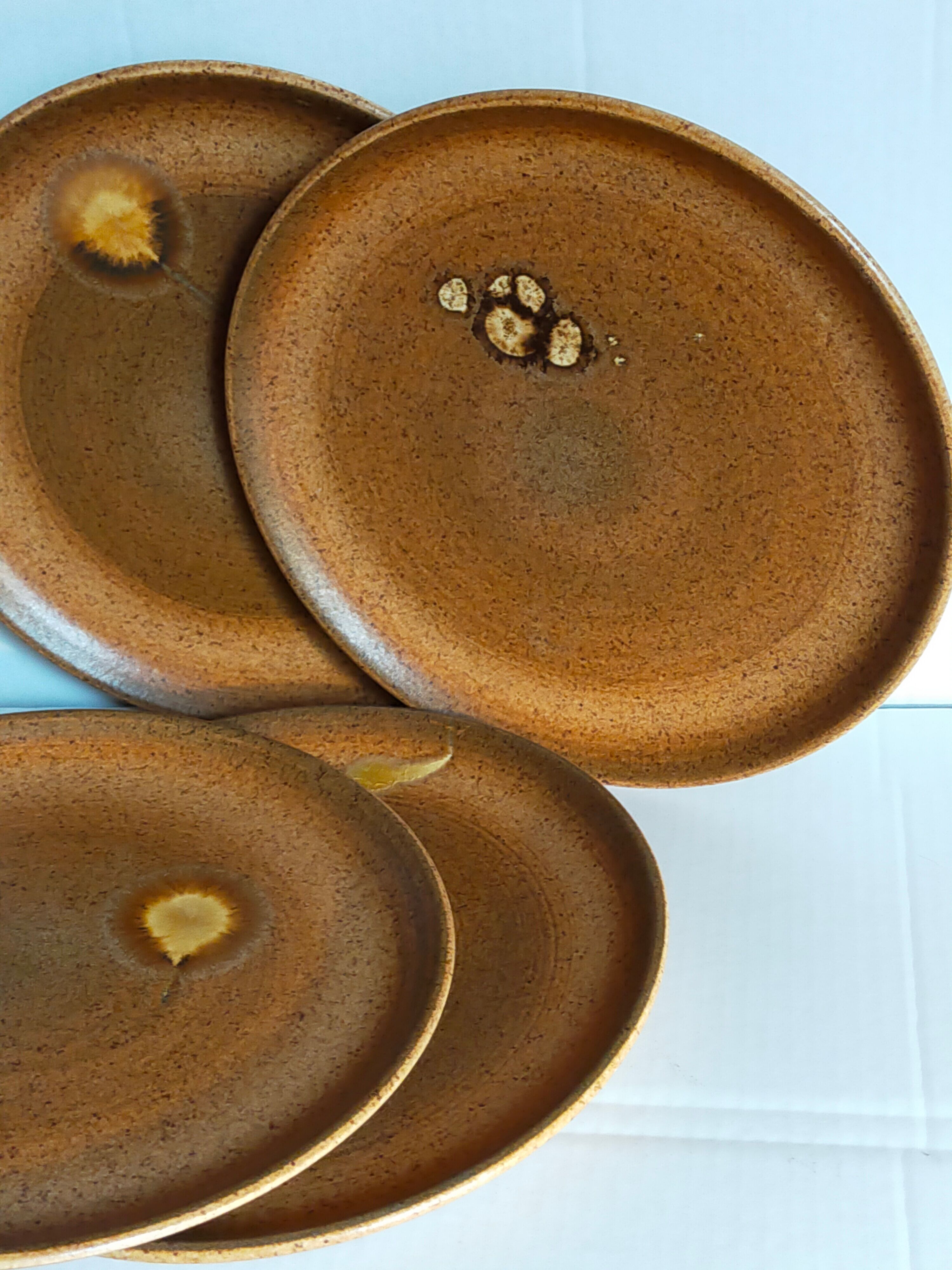 Four vintage glazed stoneware potter's plates