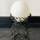 Handcrafted wrought iron lamp with a white opaline globe.