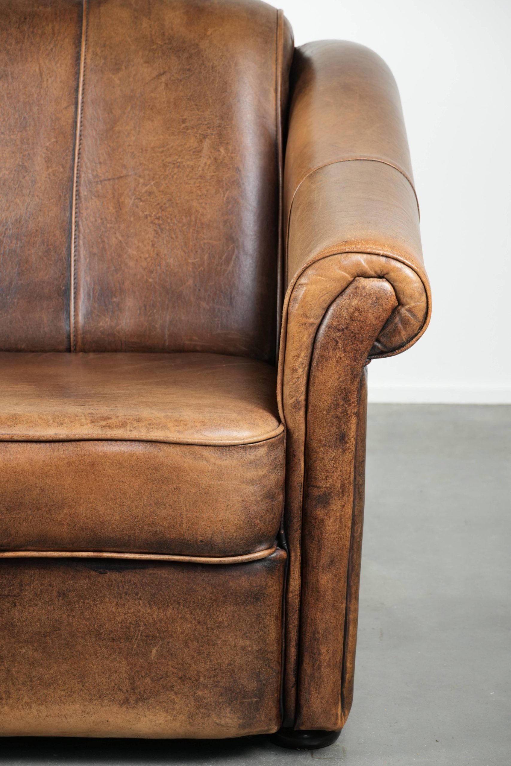 Fauteuil en peau de mouton magnifiquement conçu et confortable, avec un look intemporel et une finition de passepoil assortie.