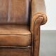 Fauteuil en peau de mouton magnifiquement conçu et confortable, avec un look intemporel et une finition de passepoil assortie.