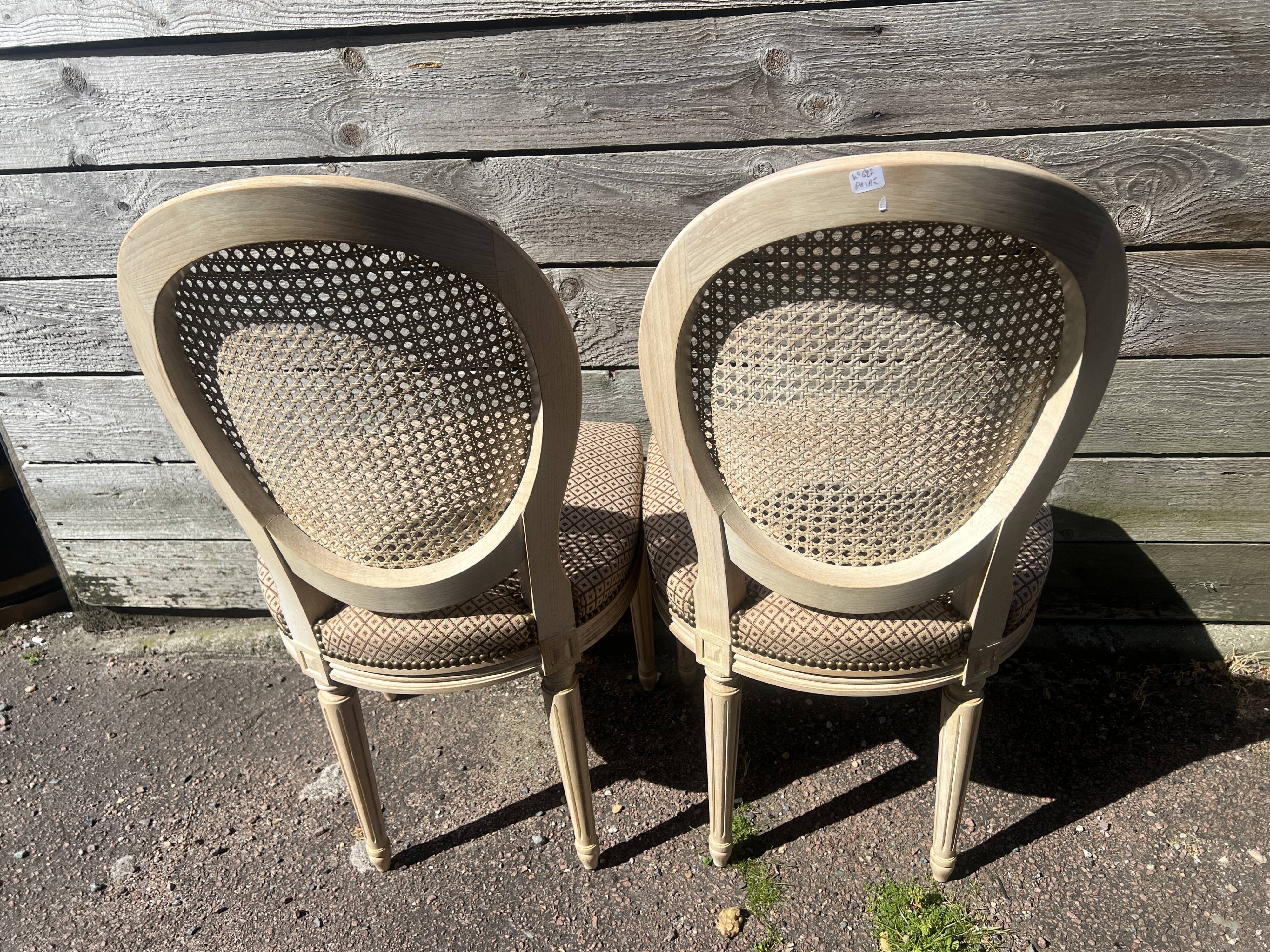 Pair of cerused chairs with fabric seats and caned backs.