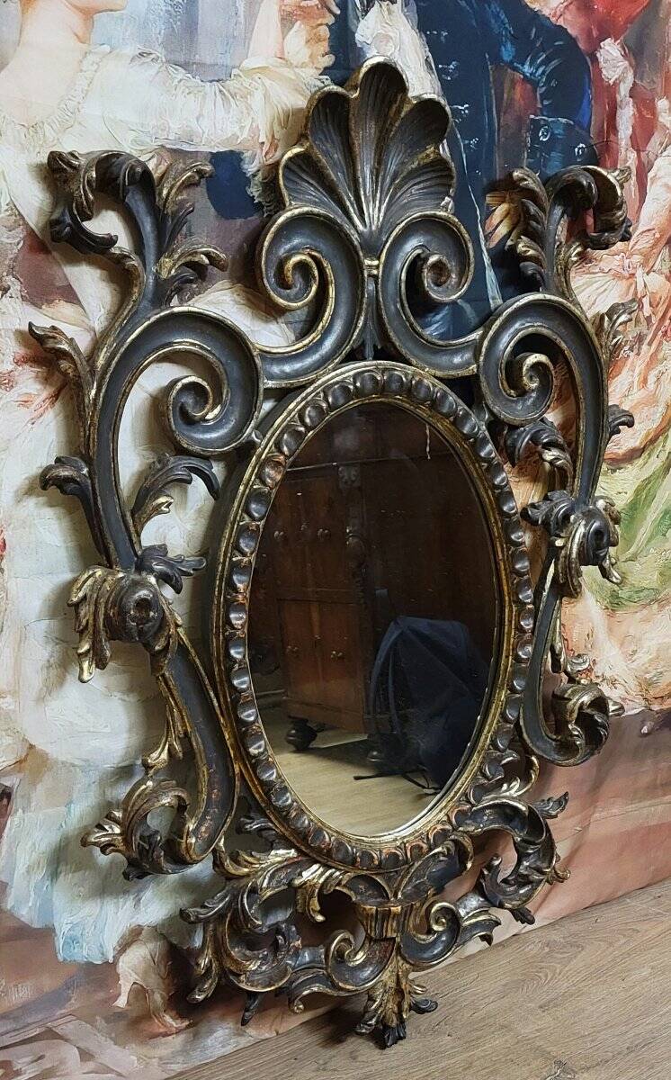Antique Louis XV style mirror, richly carved with decorations of scrolls, shells, and foliage.