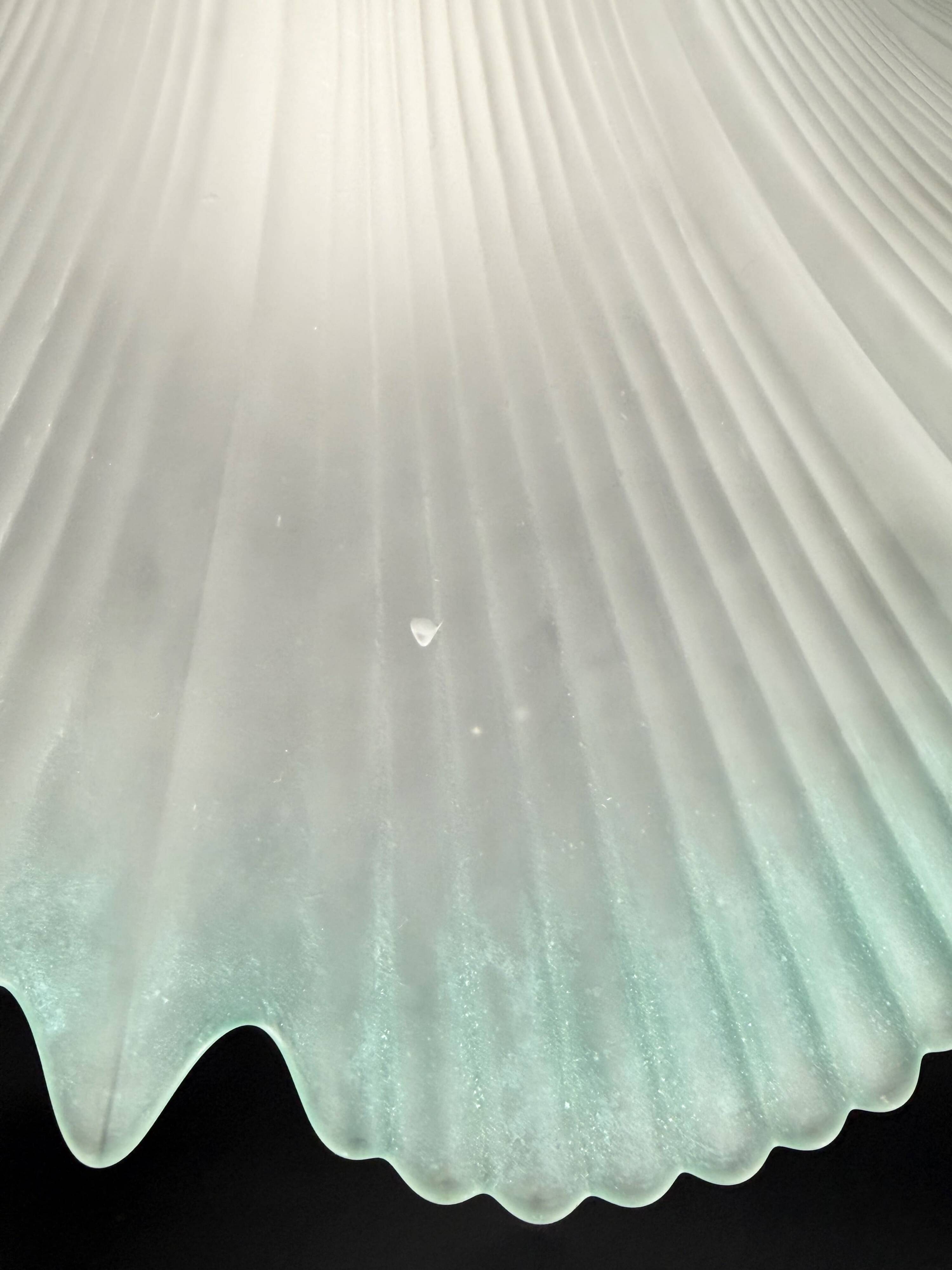 Frosted glass flower pendant with a water green edge.