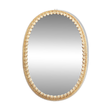 Large oval Florentine mirror in carved wood and gilded with gold leaf.
