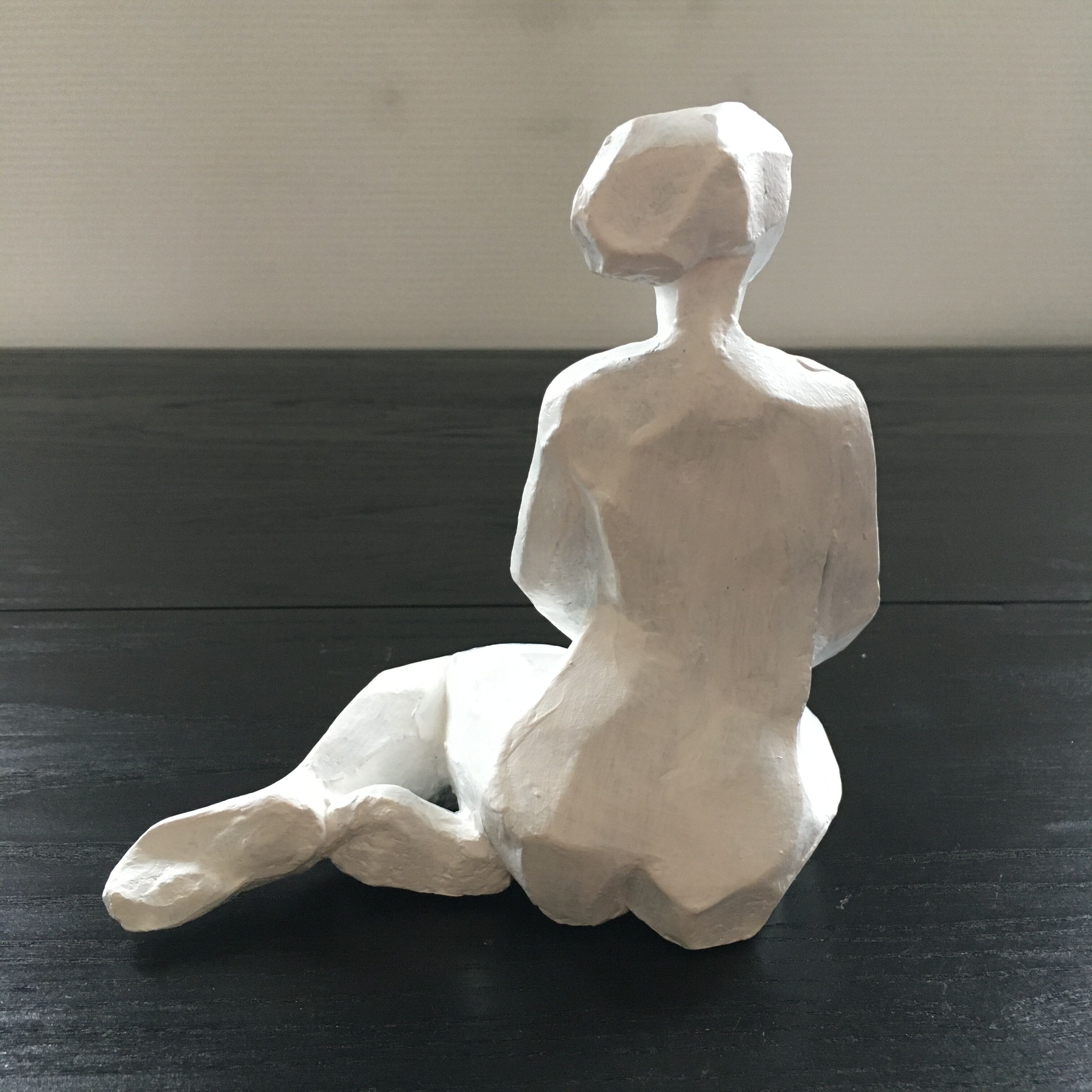 Statuette woman seated in plaster