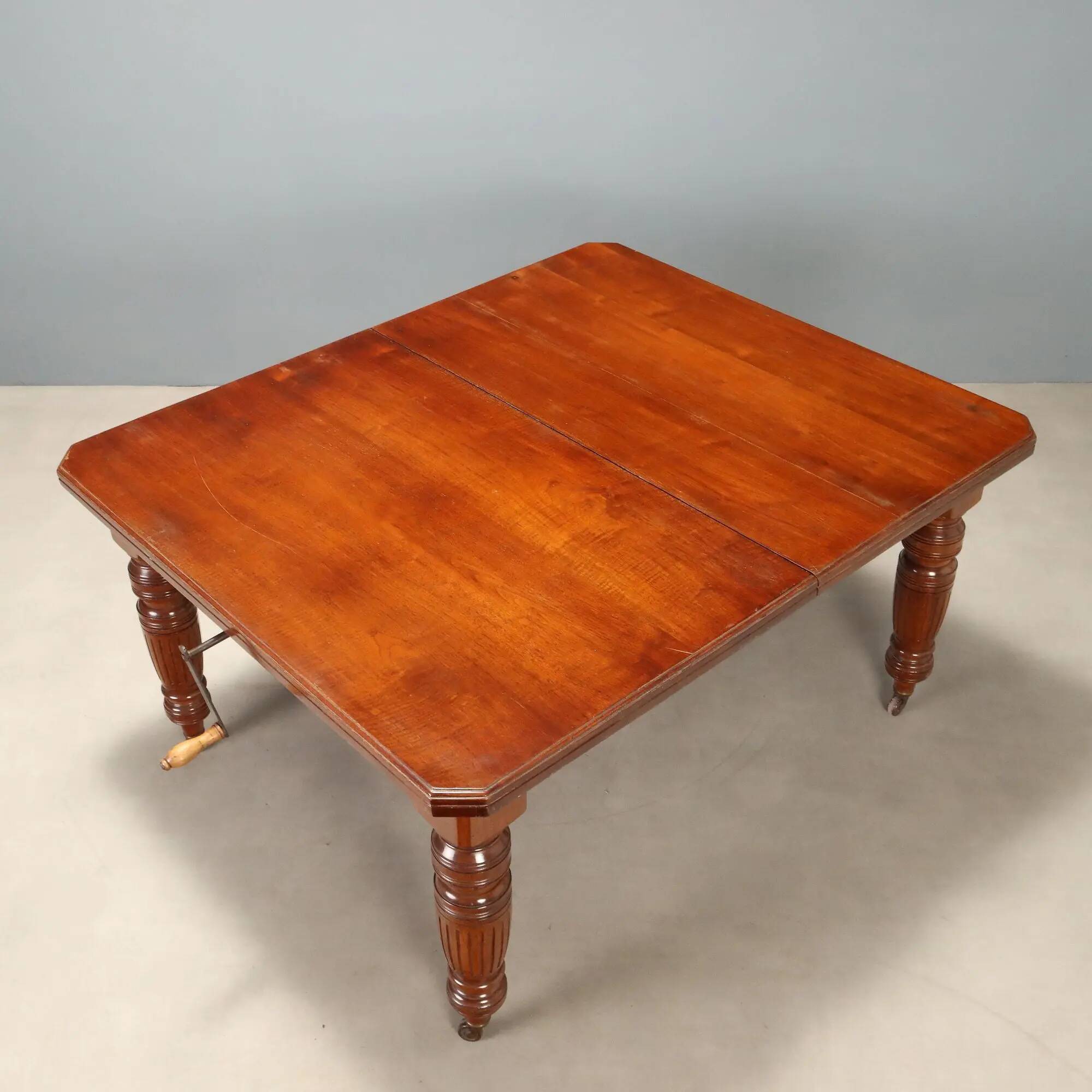 Antique extendable mahogany table with a crank mechanism, United Kingdom.