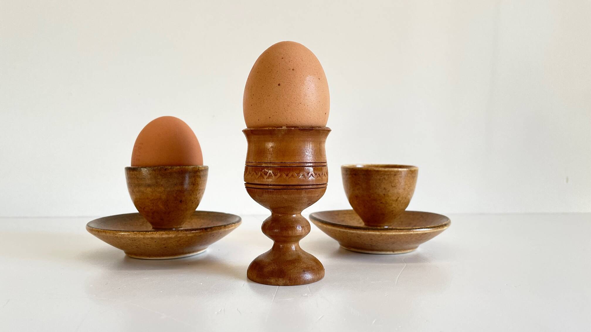 Trio of vintage ceramic and wood egg cups