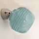 Wall light in ceramic with a light blue glass globe.
