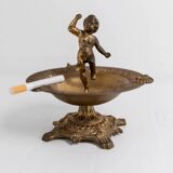 Vintage brass ashtray from the 1940s with a nude boy figurine on a footed base.