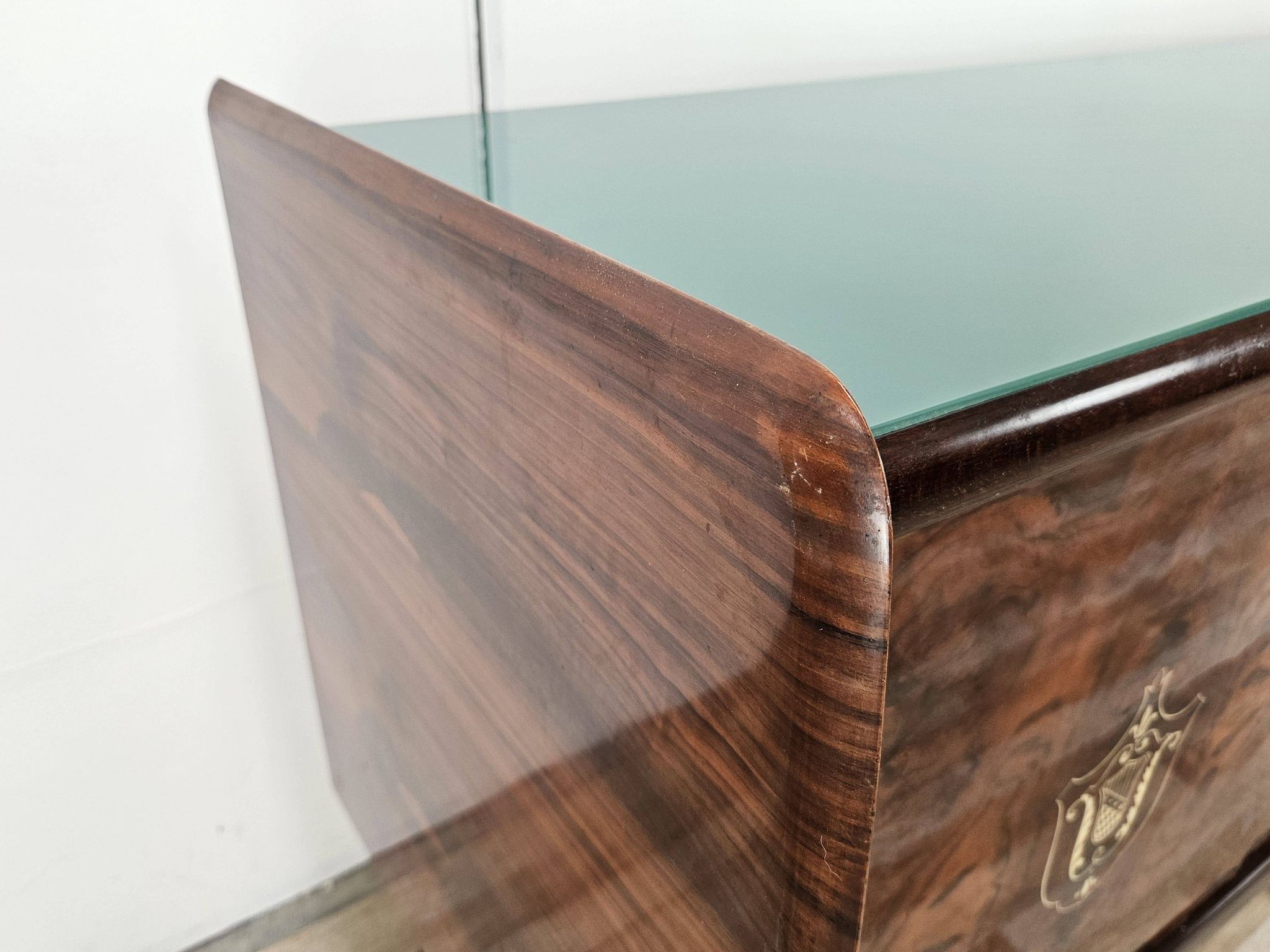 Mid-century mahogany buffet with teal glass and compartments with a drawer.