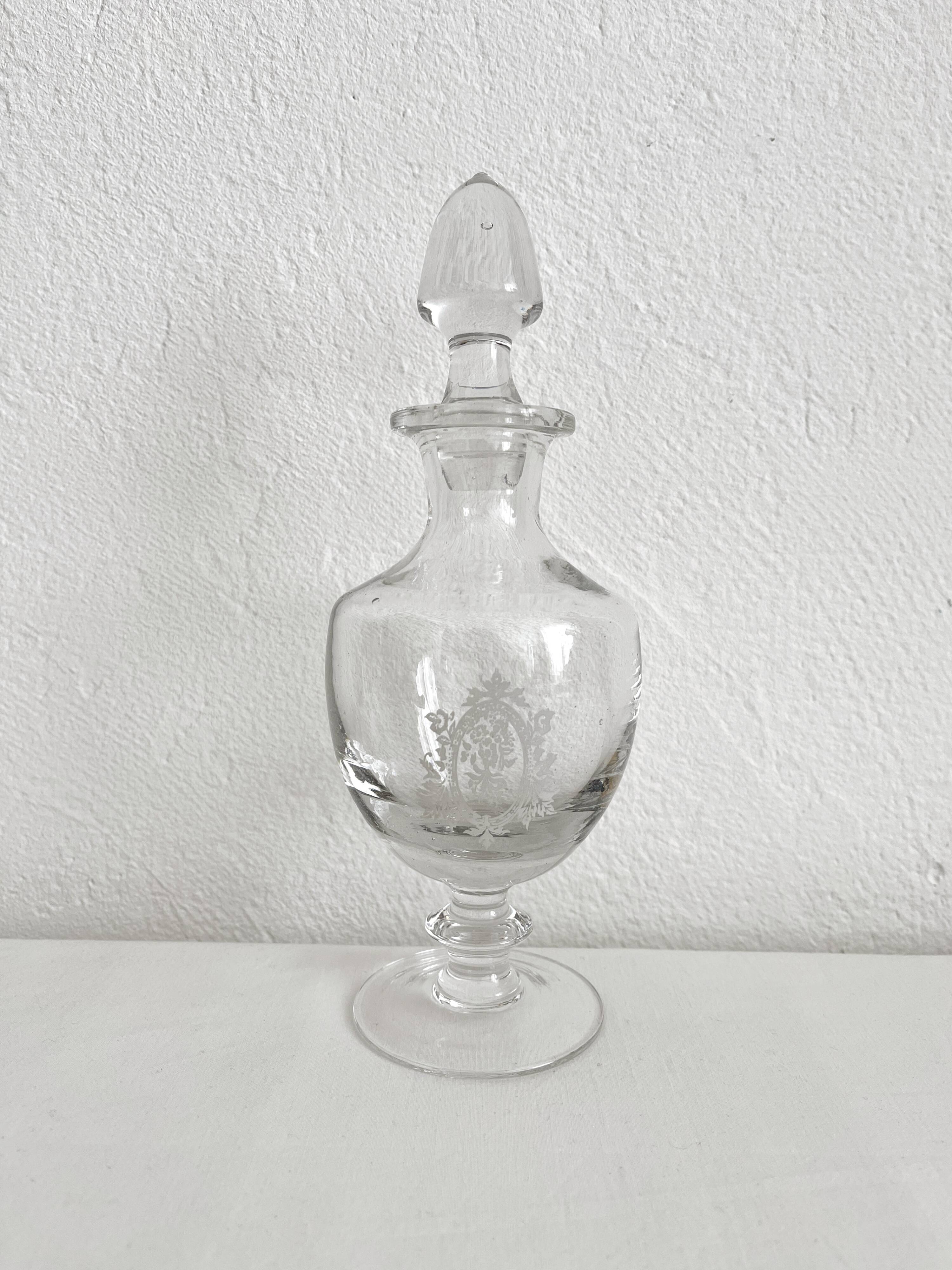 Antique stemmed blown glass bottle with engraved medallion