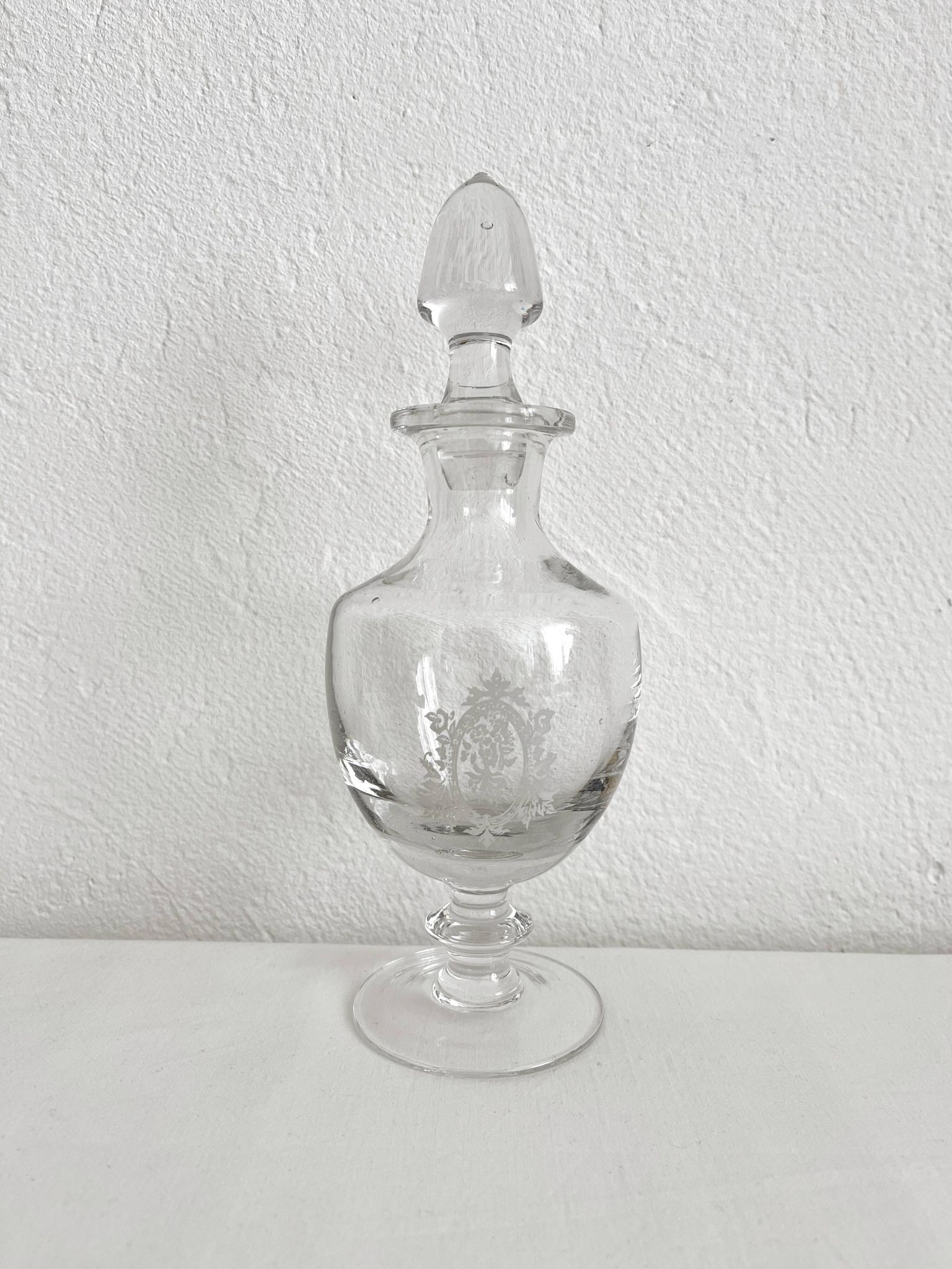 Antique stemmed blown glass bottle with engraved medallion