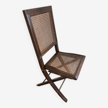 Vintage folding chair with cane seat in dark mahogany wood