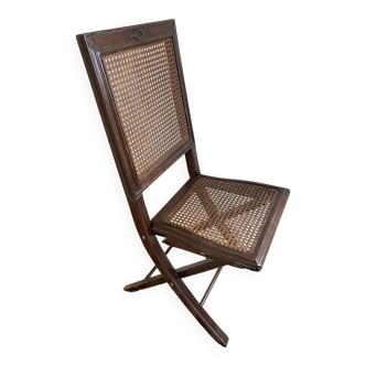 Vintage folding chair with cane seat in dark mahogany wood