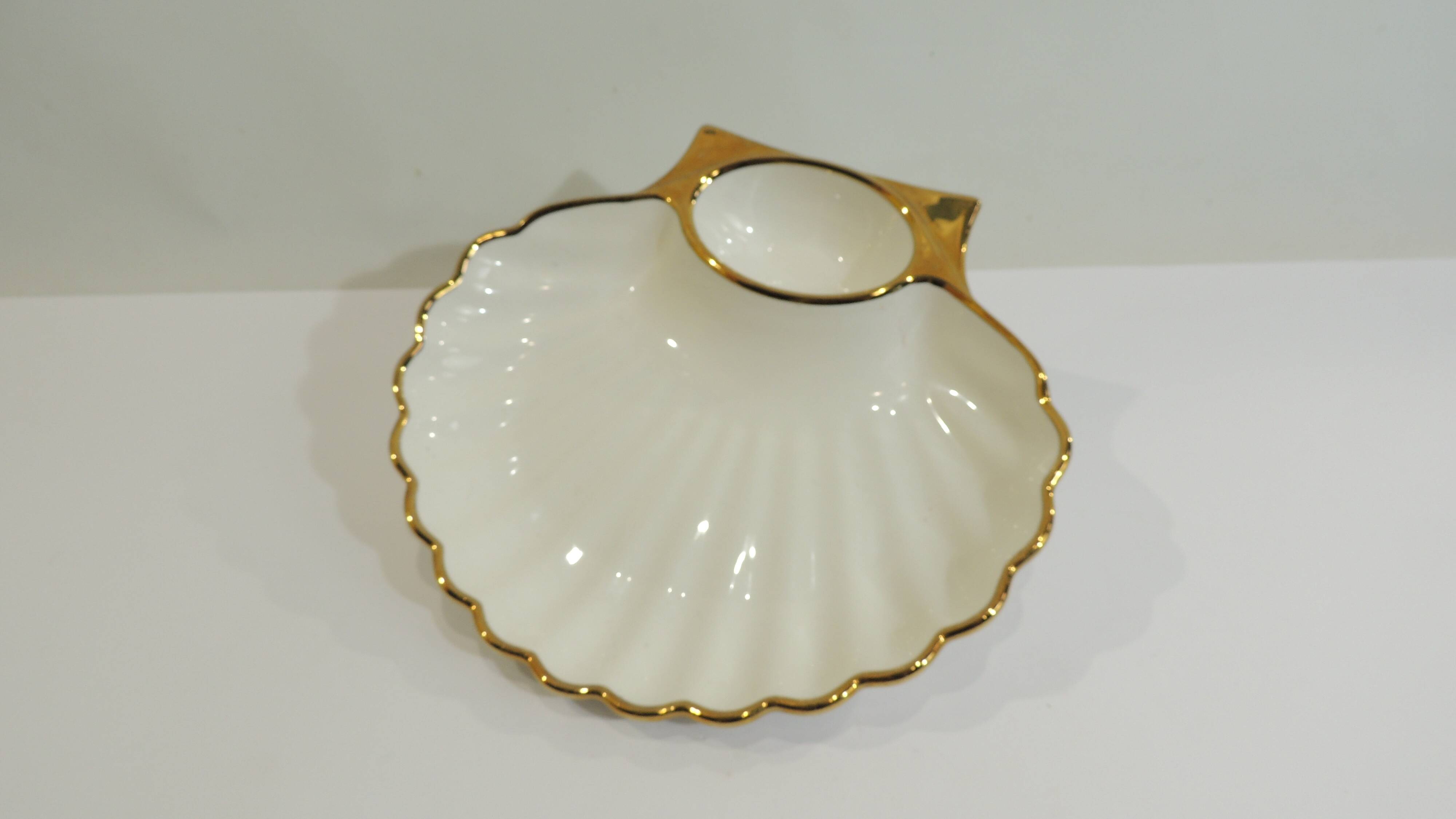 Shell-shaped porcelain pocket bowl from Queen’s Porcelain, with a gold rim.