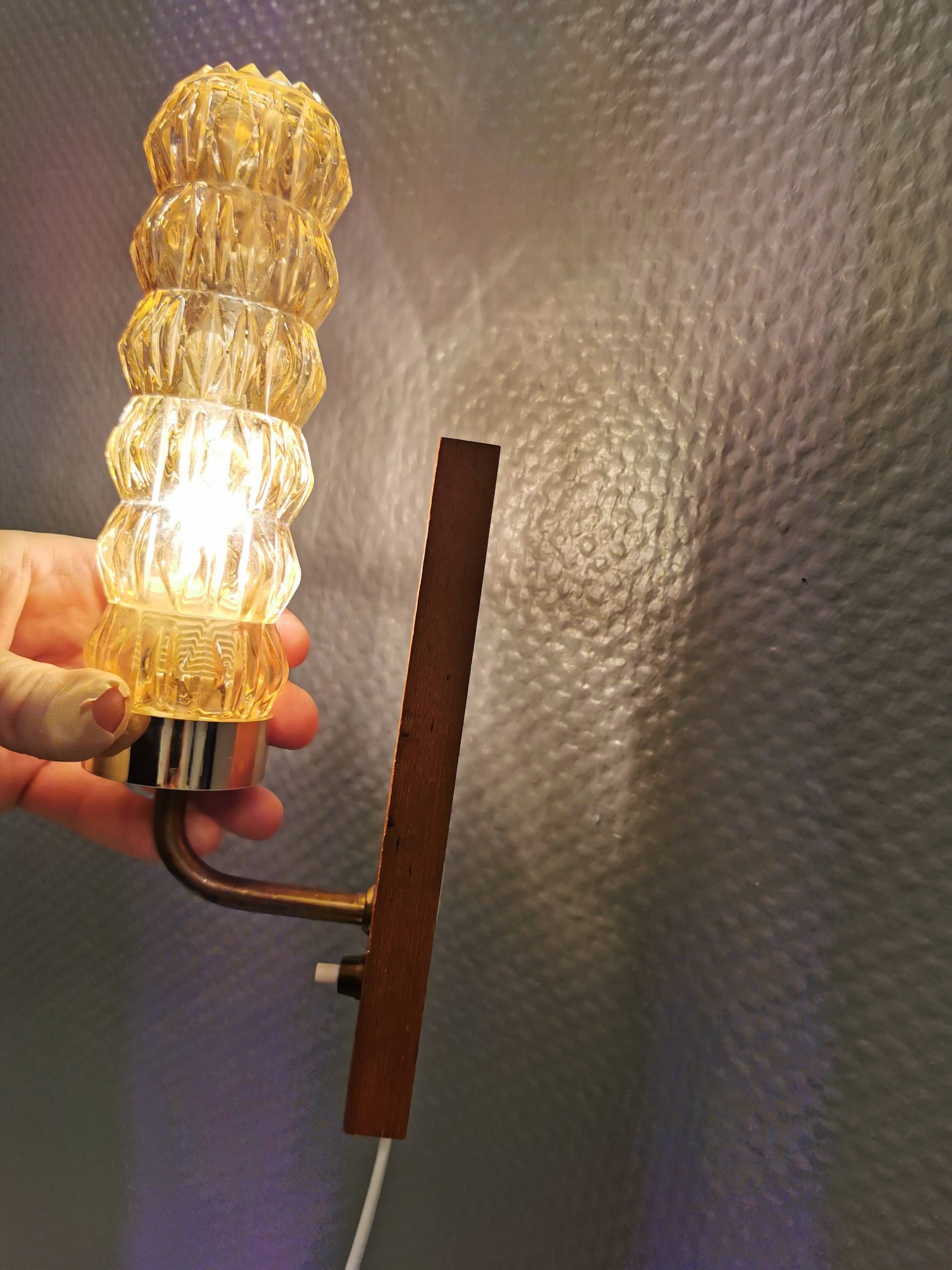 A set of Danish wall lights in champagne coloured glass with brass and teak.